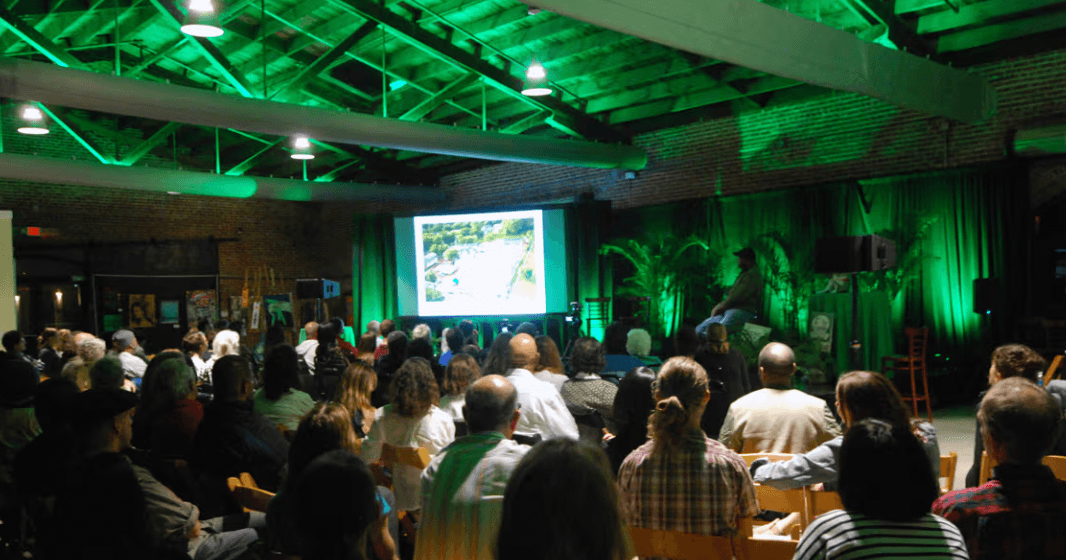An OPEN gathering with a speaker addressing a packed hall